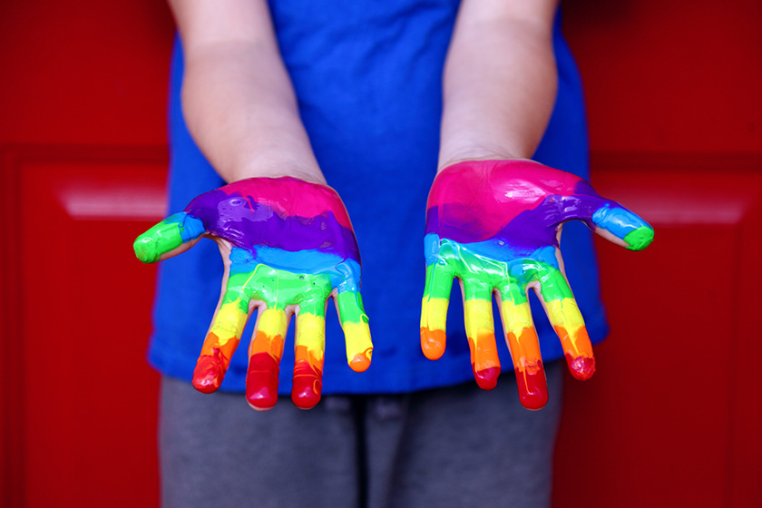 Händer målade i regnbågsfärger